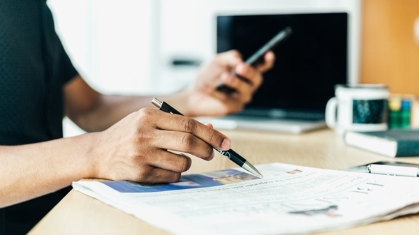 Man -at -desk -looking -at -his -newspaper